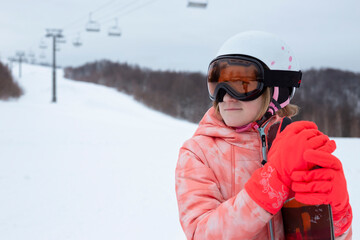Fototapeta na wymiar happy girl in ski resort riding snowboard