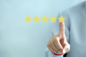 Customer review good rating concept hand pressing five star on visual screen and positive customer...