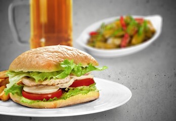 Sandwich with sausage and cucumber on desk in the room