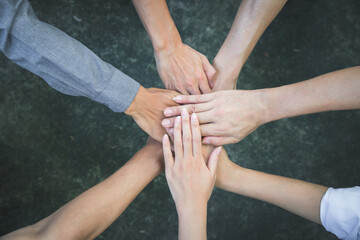 Top view of group of people team showing unity with putting their hands together in circle. Diversity hands join together for support and teamwork. Concept of teamwork.