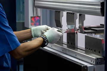 The technician operator working with hydraulic press brake bending machine.