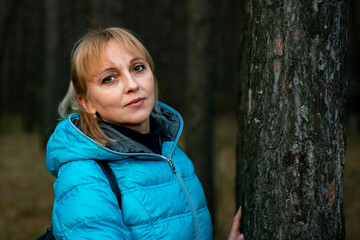 Portrait of a girl in the autumn forest in a blue jacket.
