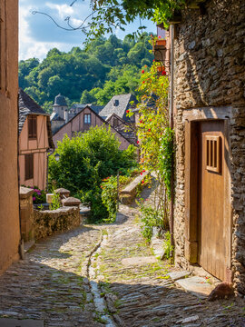 A typical narrow cobblestone street of Conques, France
