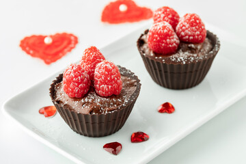 Two chocolate raspberry cups on a small platter for Valentines Day.
