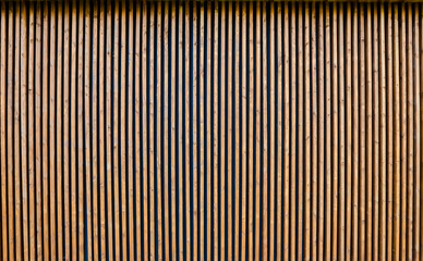 The wall is made of thin wooden vertical slats.