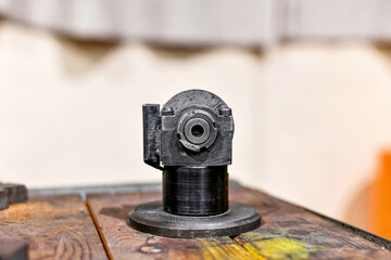 In the workshop, on a wooden table, a sharpener for an abrasive wheel.