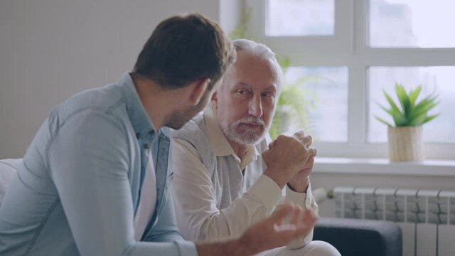 Helpful adult son supporting senior father upset with problem, family care