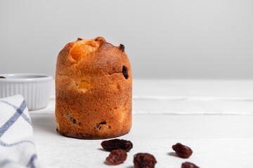Festive Christmas dessert Panettone with raisins on white wooden background with copy space