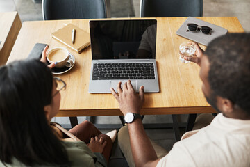 Top down view at of two business people meeting at cafe table and discussing work