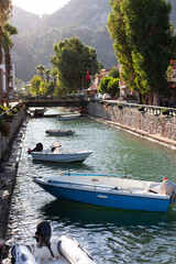 Naklejka premium Motor boats moored at the water channel. Small fisher boat tied on river in small tourist village.