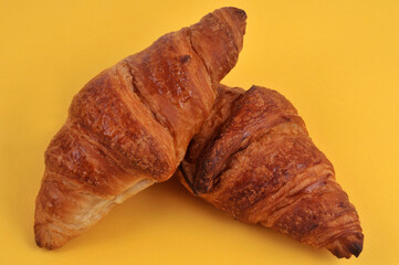 Croissants au beurre en gros plan sur fond jaune