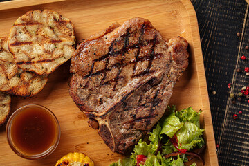 Closeup on grilled beef steak set with salad and sauce