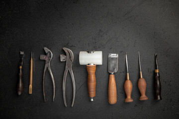 Set of leather craft cobbler tools on black background