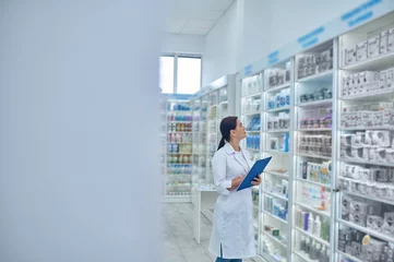 Schilderijen op glas Apotheker die medicijnen in een drogisterij controleert © zinkevych