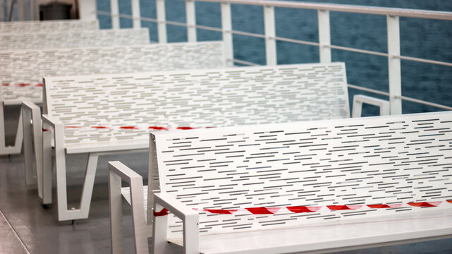 empty benches with rad and white ribbon  on the farry