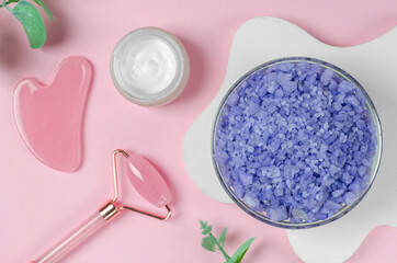 Obraz na płótnie Canvas Lavender sea salt on a pink background. Spa composition with selective focus