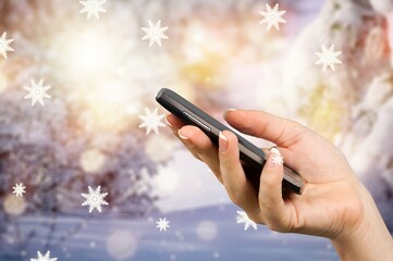 Human hand using a mobile phone on Christmas background