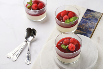 Italian dairy dessert panna cotta with raspberry jam and fresh raspberries on marble board