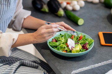 Close up picture of woman eating salald