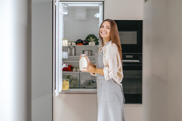 Young woman taking food from the fridge