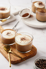 Italian chocolate and coffee mousse dessert semifreddo - half-frozen ice cream with whipped cream and cocoa powder in small glasses