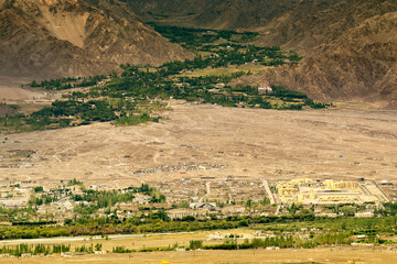 aerial view of ladakh landscape, green valley field witin barren mountains, light and shadow - obrazy, fototapety, plakaty