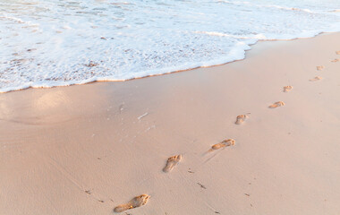 Footprints are on wet sand of the beach, summer vacation