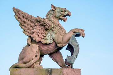 Scary ancient griffin from Moltke Bridge at blue sky background in Berlin historical and business...
