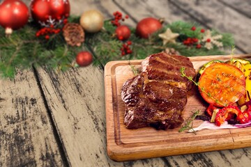 Christmas dinner for two. Baked beef with spices with Christmas tree decorations