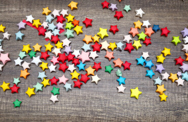 Colorful paper lucky stars on wooden table