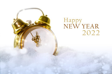 vintage alarm clock without numbers in the snow and text Happy New Year 2022, white background with...
