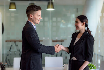 Fototapeta na wymiar Business success. Businessman and businesswoman shaking hands agreement confirmed in the investment business.