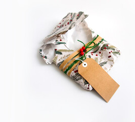 Torn, empty Christmas wrapping paper, twine, ribbon, present topper and a blank gift tag. Copyspace, isolated on white background. Opening Christmas gift or present concept.