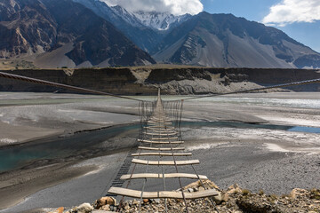 Suspension bridge passu cones mountain range rocky scenery. High quality photo