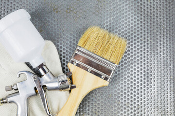 Instructions and a paint spray gun at work at the workplace in the workshop.
