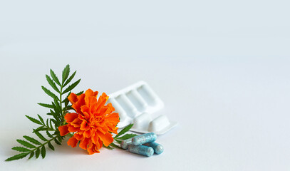 Vitamins. Dietary supplement capsules of Marigold flowers on white background. Concept: vision improvement, eye health care, phytotherapy. Selective focus. Copy space for text © Irina Ermakova