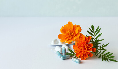 Vitamins. Dietary supplement capsules of Marigold flowers on white background. Concept: vision...