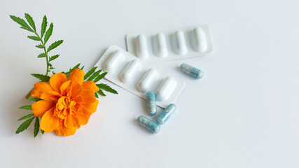 Vitamins.Dietary supplement capsules of Marigold flowers on white background. Concept: vision...