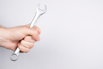 wrench on a white background. Man hand holding a wrench, free space. Repair of machines and equipment