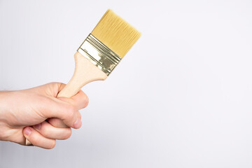 Large clean paint brush on a white background. Man hand hold paintbrush