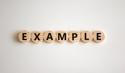 Example symbol. The concept word Example on wooden circles. Beautiful white background, copy space. Business and example concept.