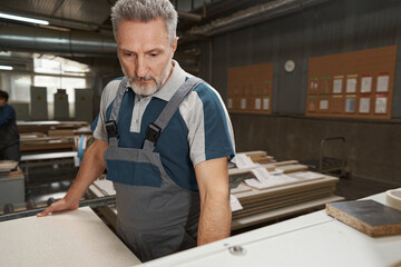 Close up of serious carpenter holding plank
