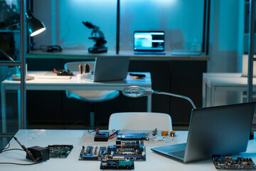 Workplace of repairman or technician with laptop, magnifying-glass, repairing equipment and hardware on desk in laboratory