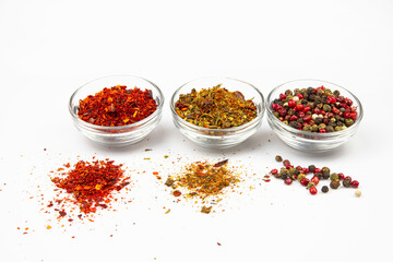 Glass bowls with a variety of spices and seasonings isolated on a white background.