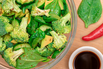 Fresh Green Salad of Avocado, Broccoli, Spinach and Cucumber with Soy Sauce and Red Hot Pepper on...
