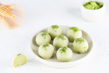 Green truffles with matcha and limes on a plate. Sugar, gluten and lactose free.