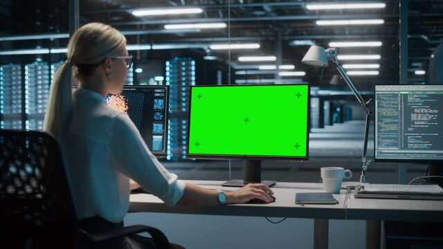 High-Tech Data Center Server: Caucasian Female IT Specialist Working on Green Screen Chroma Key Computer. Monitoring Web Services, Cloud Computing, Analytics Facility, Maintenance of Cyber Security