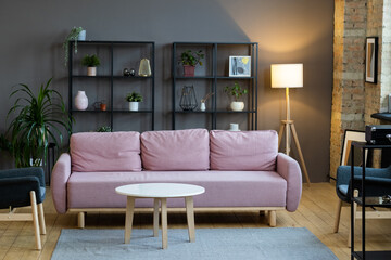 Image of comfortable pink sofa with coffee table in front of it in the modern living room