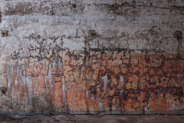 Cracked plaster on the concrete wall of an abandoned fort