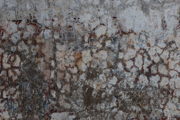 Cracked plaster on the concrete wall of an abandoned fort